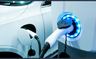 Electric vehicle recharges its battery by plugging into EV charging point.