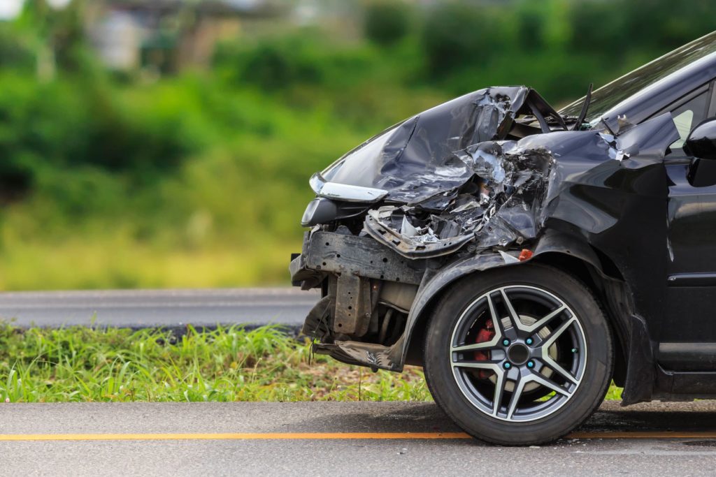 How to check car accident history in UAE; front of black car damaged by accident on the road