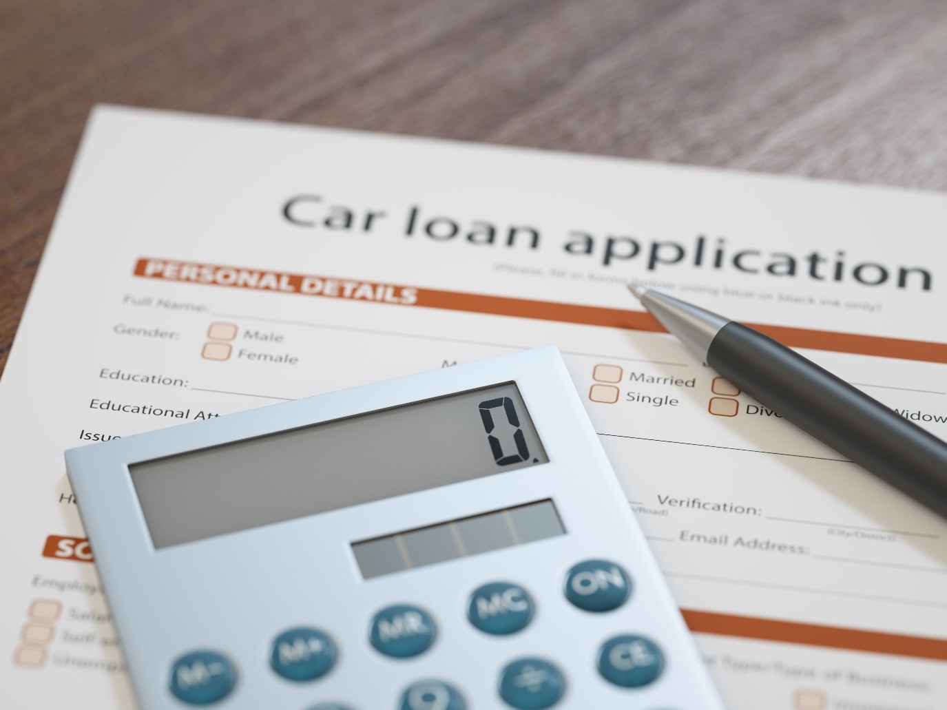 How to get a car on finance with a car loan application with a calculator to calculate your car finance and a pen resting on top