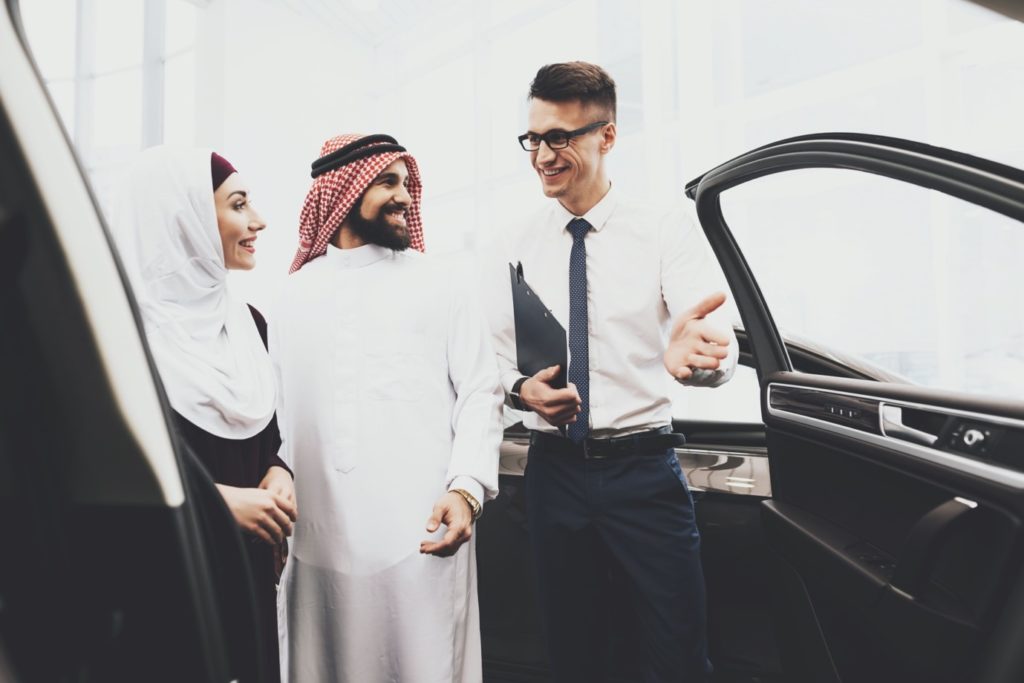 A seller shows a used car to buyers in the UAE, showing how to sell a used car by understanding what buyers look for
