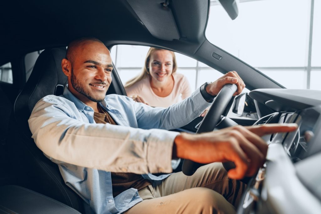 Letting the buyer take the car for a test drive is essential to sell your car in Dubai; a woman shows an interested buyer the features of the car for sale